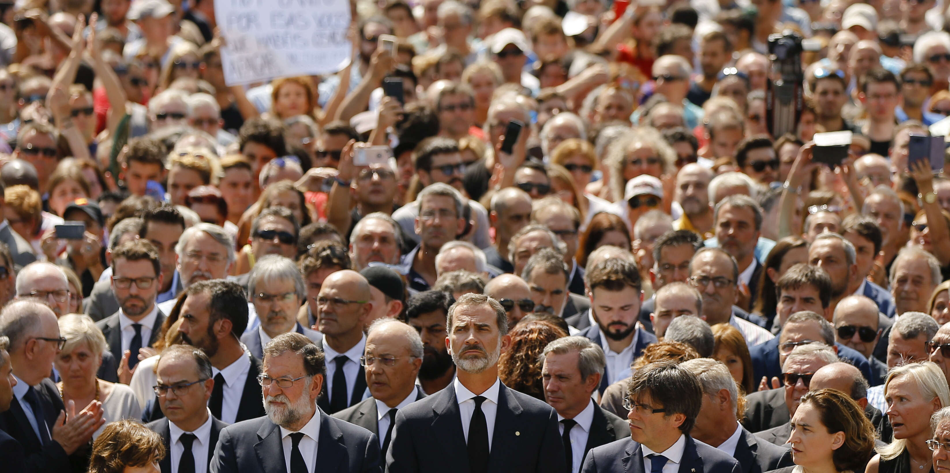 King Felipe of Spain, center, Prime Minister Mariano Rajoy, center left, and and Catalonia regional President Carles Puigdemont, center right, join people observing a minute of silence in memory of the terrorist attacks victims in Las Ramblas, Barcelona, Spain, Friday, Aug. 18, 2017. Spanish police on Friday shot and killed five people carrying bomb belts who were connected to the Barcelona van attack that killed at least 13, as the manhunt intensified for the perpetrators of Europe's latest rampage claimed by the Islamic State group. (AP Photo/Francisco Seco)
