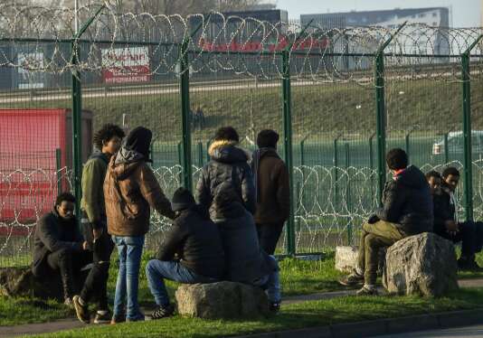 Des migrants attendent près d’un parking à camions, à Calais (Pas-de-Calais), le 12 janvier.