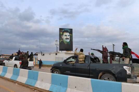 Un convoi de combattants pro-Assad passe devant un portrait du leader du Parti des travailleurs du Kurdistan (PKK) Abdullah Öcalan, à son arrivée dans la région d’Afrin, dans le nord de la Syrie.