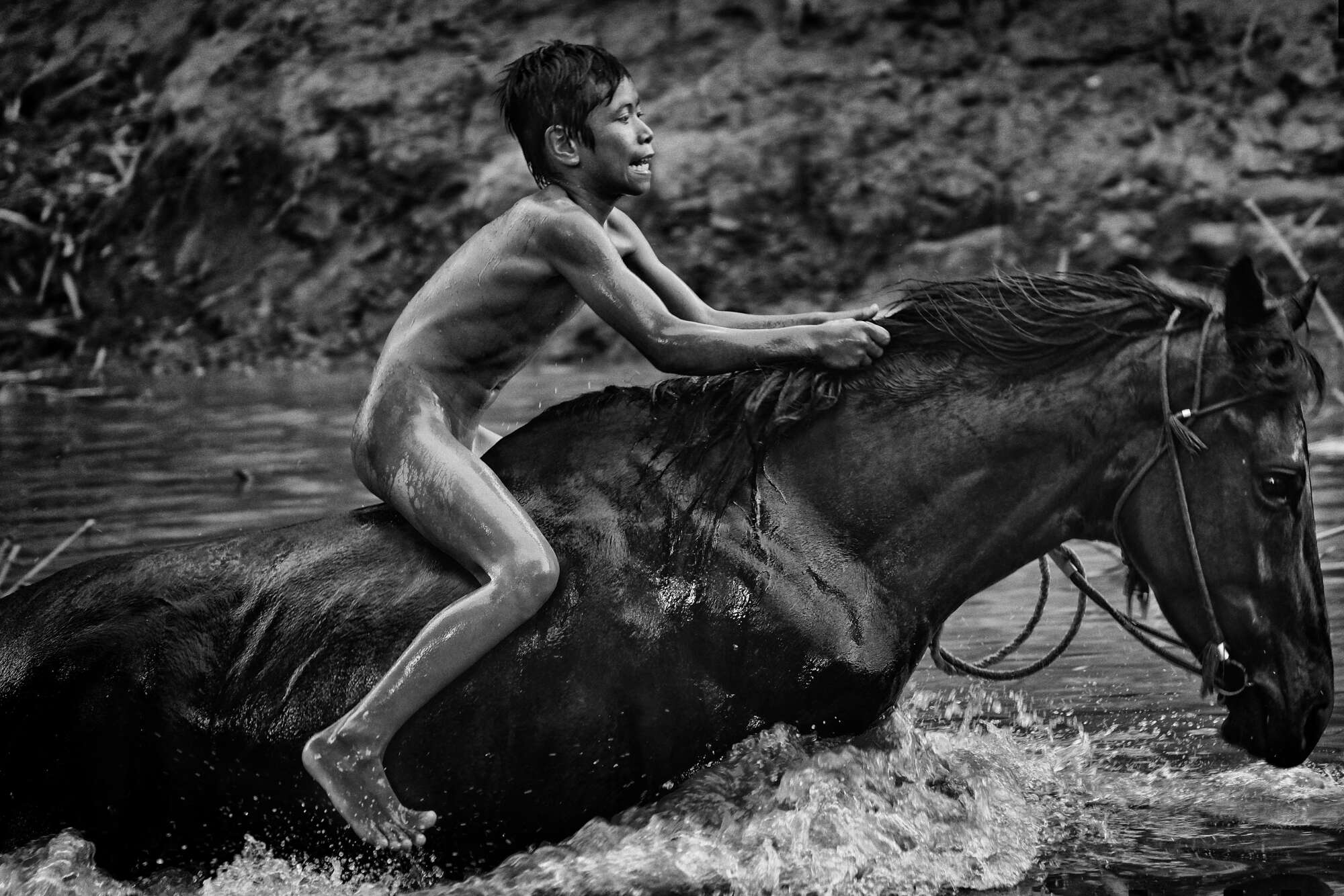 « Enfants jockey » : un cheval amené dans l’eau pour le rafraîchir après une journée de course à Maen Jaran, Sumbawa Island, Indonésie, le 17 septembre 2017.