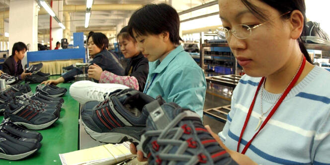 Des ouvrières chinoises confectionnent des chaussures dans une usine de la province du Fujian,le 26 décembre 2004.