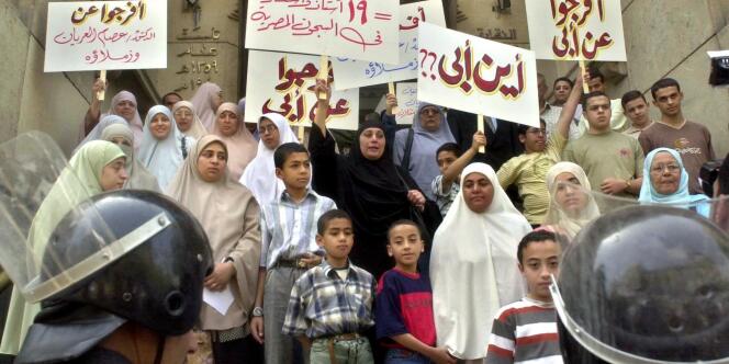Des femmes et leurs enfants manifestent contre l'arrestation de leur mari, dont le tort est d'appartenir au mouvement des Frères musulmans. On peut lire sur les pancartes : 