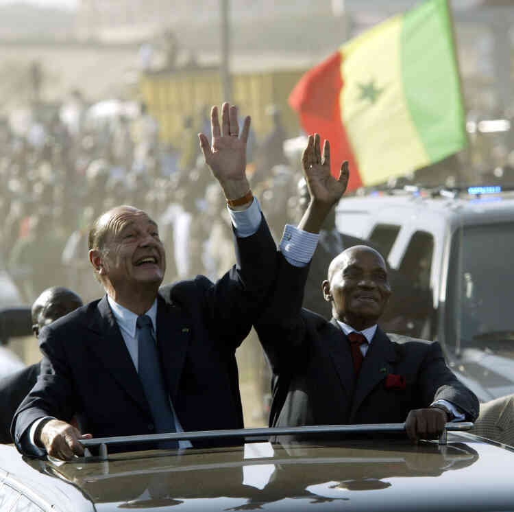 Jacques Chirac salue la foule aux cotés de son homologue sénégalais, Abdoulaye Wade, le 2 février 2005, à son arrivée à Dakar.