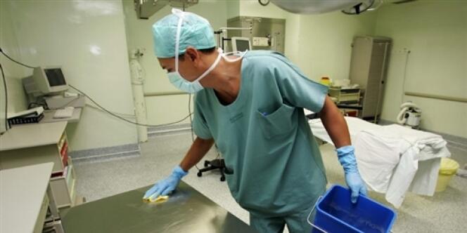 Un agent d'entretien désinfecte une table d'intervention dans le bloc opératoire de l'hôpital Nord, le 24 août 2005 à Marseille. 