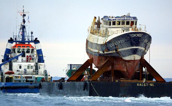 L'épave du chalutier breton « Bugaled-Breizh », sur une barge tirée par un remorqueur, en direction du port de Brest, le 13 juillet 2004.