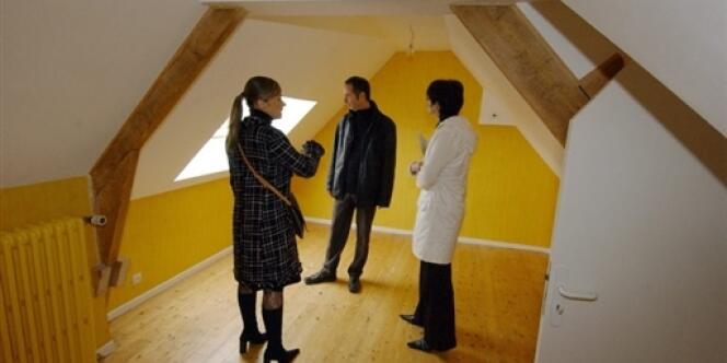 Une négociatrice immobilière fait visiter une maison à un couple à la recherche d'un logement.