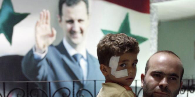 Un homme et son fils devant une affiche à l'effigie de Bachar Al-Assad, en septembre 2008.