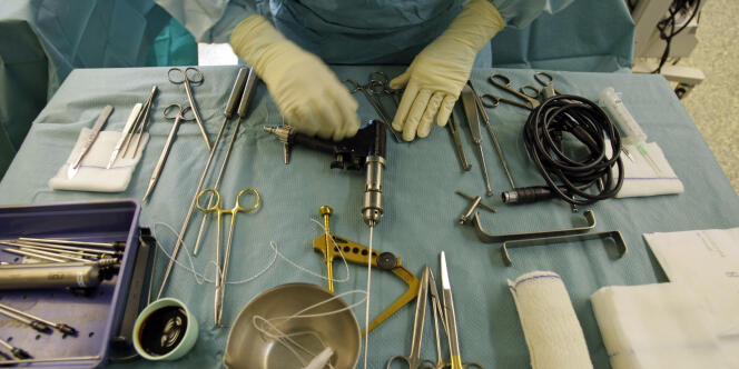 Un chirurgien inspecte ses intruments.