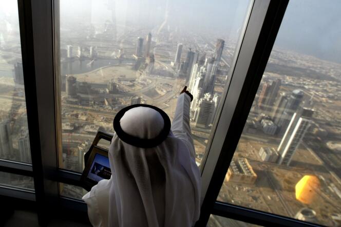 Un Emirati pointe son index du haut de Burj Khalifa à Dubaï (Emirats arabes unis), la tour la plus haute du monde (828 m), en janvier 2009. 