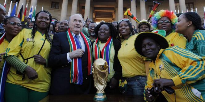 Le président de la FIFA, Joseph Blatter, apporte le trophée de la Coupe du monde au siège du gouvernement sud-africain, le 4 juin 2010 à Pretoria. 