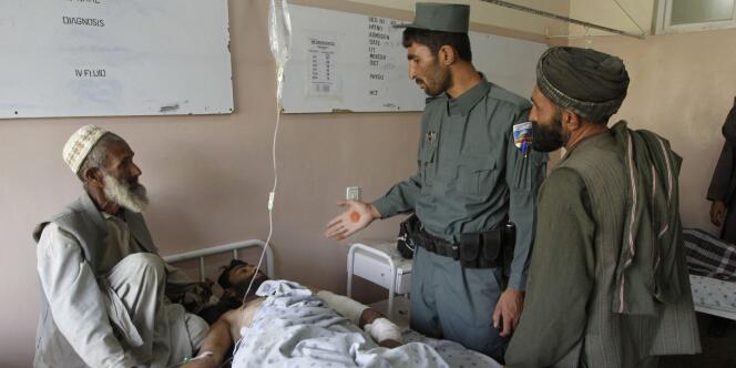 Un policier afghan visite une des victimes de l'attentat qui a visé les convives d'un mariage, dans la province de Kandahar.