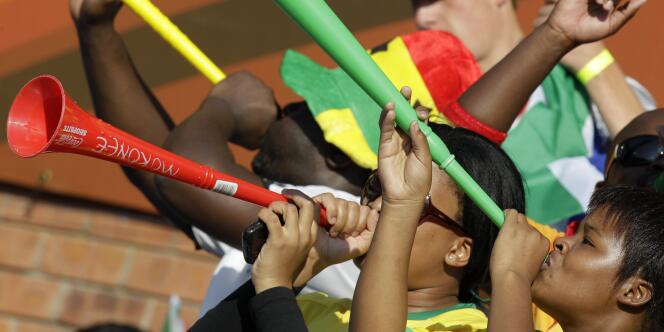 Des supporters soufflent dans leurs vuvuzelas, lors du match opposant la Serbie et le Ghana, le 13 juin.  Le bourdonnement incessant de ces trompettes en plastique lors des rencontres exaspère de nombreuses équipes et observateurs étrangers.