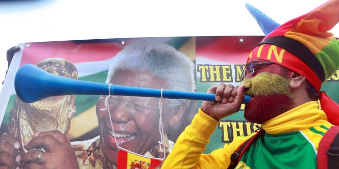 Un supporter Germano-Espagnol devant un portrait de Nelson Mandela et jouant du vuvuzela