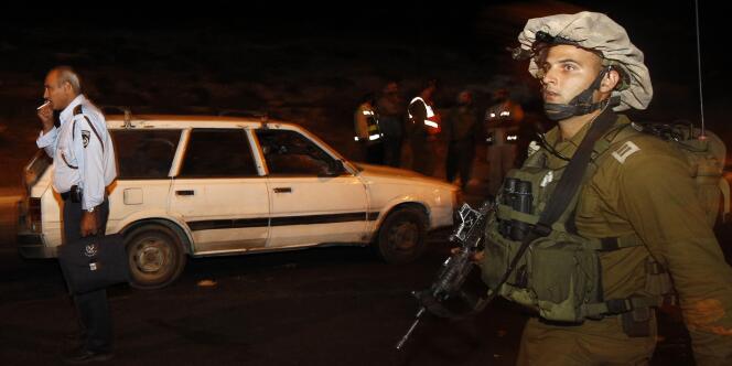 Un soldat israélien passe devant la voiture ciblée par les tirs, tuant ses quatre passagers.