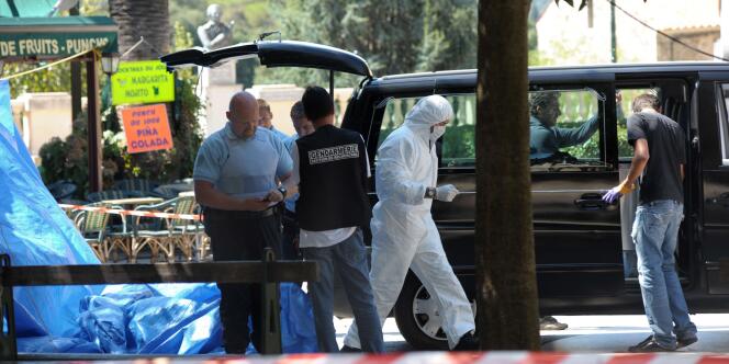 Des gendarmes évacuent le corps d'un homme décédé lors d'une fusillade, le 4 septembre 2010 sur la place centrale de Sartène.