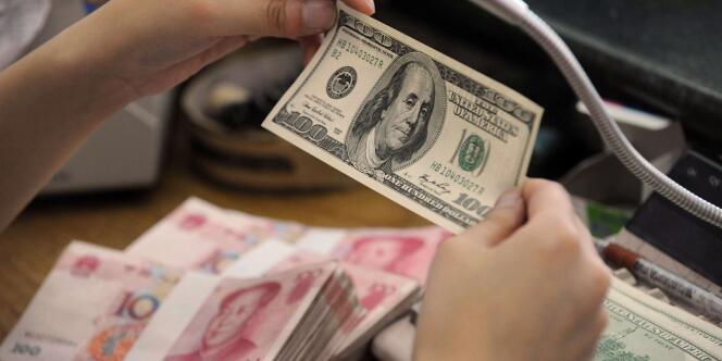 Une employée manipule des dollars et des yuans dans une banque chinoise, le 3 septembre 2010.
