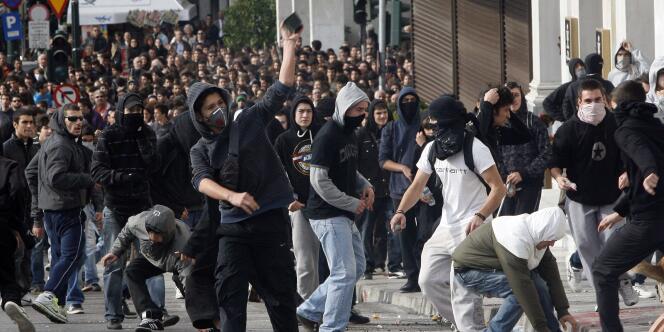 Un jeune manifestant grec lance un pavé contre les membres des forces de l'ordre, lundi 6 décembre.