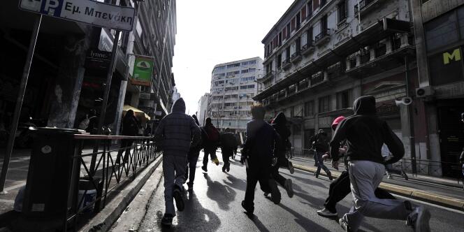 Des manifestants s'enfuient dans les rues d'Athènes après des affrontements avec la police, lundi 6 décembre.