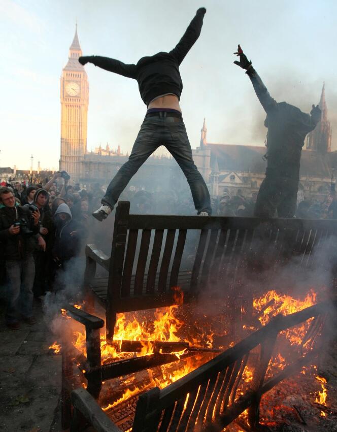 Des manifestants mettent le feu à des bancs publics, devant Westminster, jeudi 9 décembre.