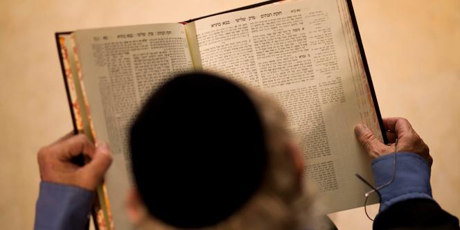 Un rabbin tient un exemplaire du Talmud entre les mains.