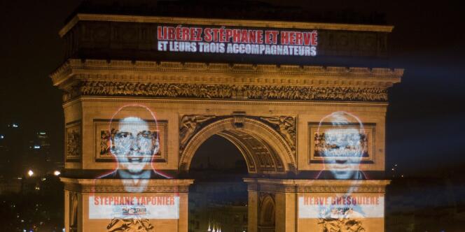 Les visages de Stéphane Taponier et Hervé Ghesquière projetés sur l'Arc de triomphe, mercredi 29 décembre.