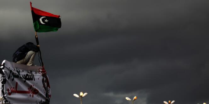 Un manifestant anti-Kadhafi exhibe l'ancien drapeau libyen, à Benghazi, le 27 février 2011.