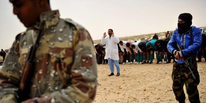 Des combattants rebelles libyens font la prière avant d'affronter les forces pro-Kadhafi près de Ras Lanouf, vendredi 4 mars 201.