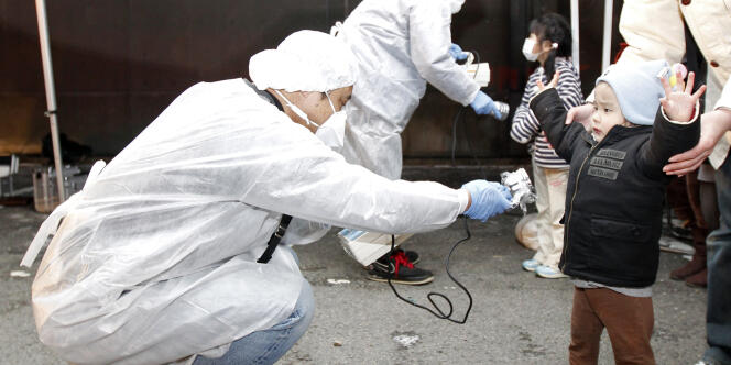 Des enfants évacués de la zone interdite autour de la centrale de Fukushima sont examinés, le 13 mars 2011. 
