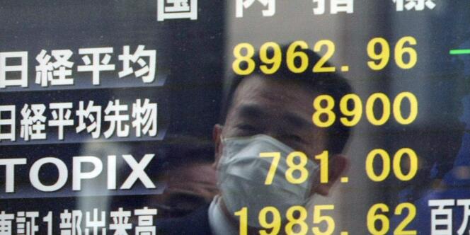 Vue d'un panneau montrant les indices boursiers, à Tokyo, le 15 mars 2011.