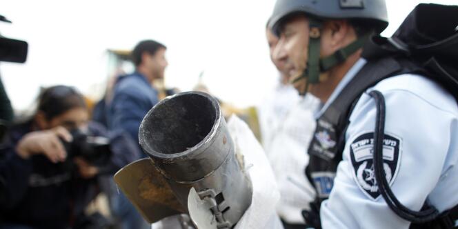 Un officier de police israélien tient les restes d'une roquette tirée de la bande de Gaza. 