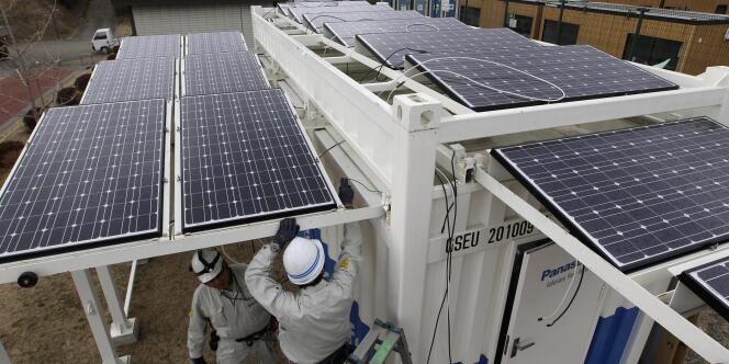 Installation de panneaux solaires au-dessus d'un bâtiment public à Minami-Sanriku, ville du nord-est de Honshu dévastée par le séisme du 11 mars.