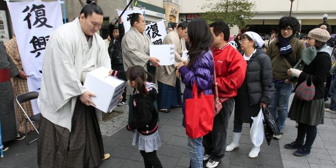 Le champion sumo Hakuo vient en aide aux victimes du tsunami à Tokyo le 24 mars. 