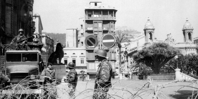 Des soldats français, en position sur un camion militaire, patrouillent le 14 juin 1962 sur la Place d'Armes à Oran.