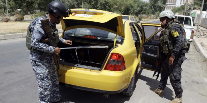 Des policiers irakiens contrôlent un véhicule, à Bagdad, le 20 août.