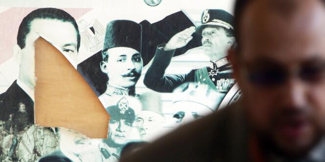 Un homme, dans un bureau de vote du Caire, devant des portraits d'anciens dirigeants égyptiens. 