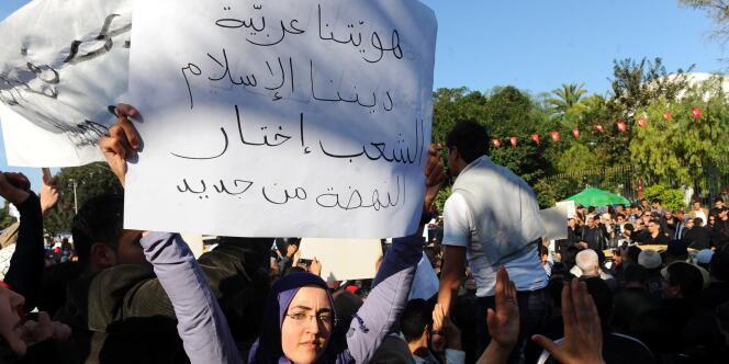 ''Nous sommes arabes, notre religion est l'islam, le peuple tunisien a choisi Ennahda'', dit la pancarte de cette manifestante, à Tunis, samedi 3 décembre.