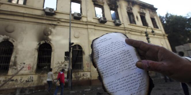 Des manifestants ont pénétré, dimanche 18 décembre, dans le bâtiment encore fumant de l'Institut d'Egypte, incendié la veille, pour en extraire des manuscrits anciens, dont une partie était brûlée.