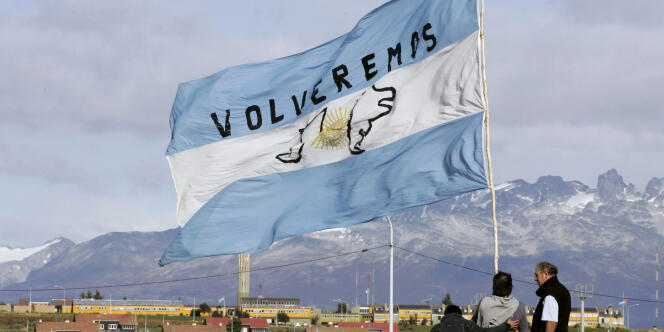 Des Argentins brandissent un drapeau sur lequel est écrit 