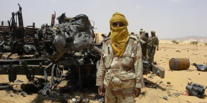 Un Touareg pose devant une carcasse d'avion. Le MNLA affirme avoir abattu un MIG-21 malien.