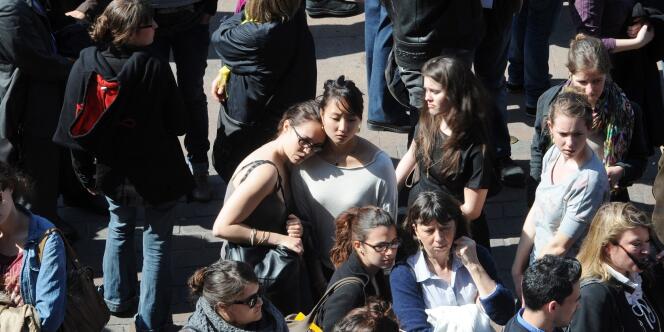 Des jeunes femmes se soutiennent lors de l'hommage aux sept victimes de Mohamed Merah, le 23 mars à Toulouse.