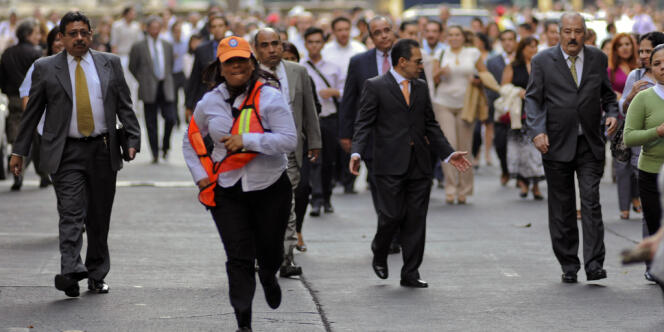 Des Capitalinos regagnent leur travail après le séisme du 11 avril 2012.