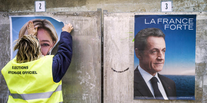 Une employée colle les affiches de campagne des candidats à la présidentitelle de 2012.