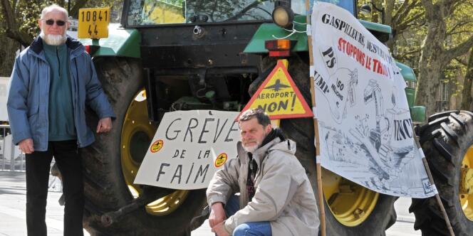 Deux agriculteurs, Michel Tarin (à gauche) et Marcel Thébault (à droite) posent devant un tracteur en face de la préfecture, le 12 avril 2012 à Nantes, alors qu'ils ont entamé une grève de la faim pour protester contre le  futur aéroport nantais de Notre-Dame-des-Landes.
