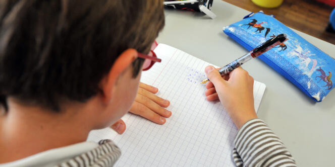 Un élève écrit sur cahier dans l'une des classes de l'école Harouys à Nantes, le 05 septembre 2011, jour de la rentrée scolaire.