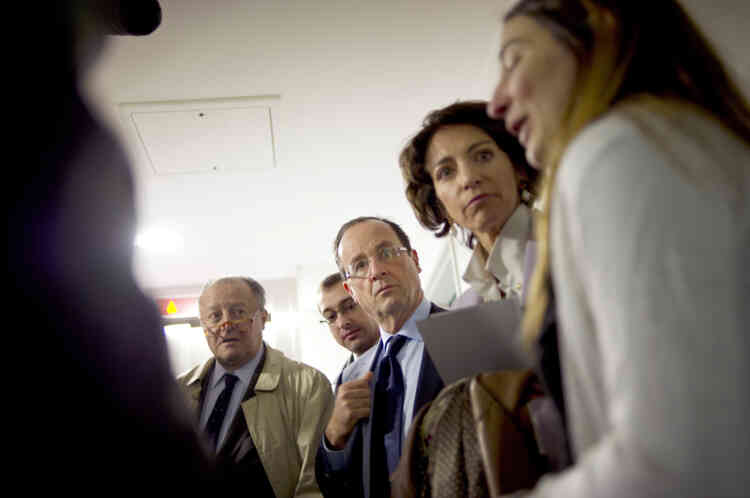 France's opposition Socialist Party (PS) candidate for the 2012 French presidential election Francois Hollande (C) flanked by Marisol Touraine (2nd R), his advisor in charge of the Welfare State, Healthcare, Elderly and Disabled People, and French MP Tony Dreyfus (L) visits a Homeless charity Emmaus emergency shelter center, on December 14, 2011 in Paris 10th district,  as part of his campaign. AFP PHOTO POOL/ FRED DUFOUR
