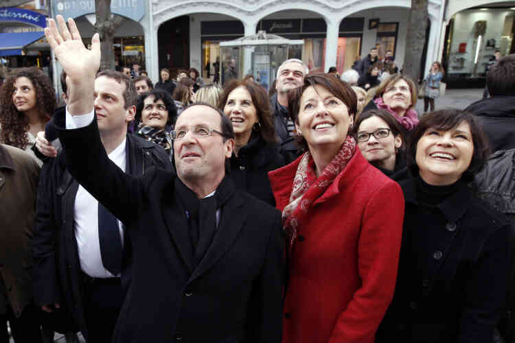 France's Socialist Party (PS) candidate for the 2012 French presidential election, Francois Hollande (L) waves next to Adeline Hazan (C), Mayor of Reims, as he walks in the street surrounded by women in Reims March 8, 2012 during a campaign trip focus on the International Women's Day. AFP PHOTO POOL GONZALO FUENTES