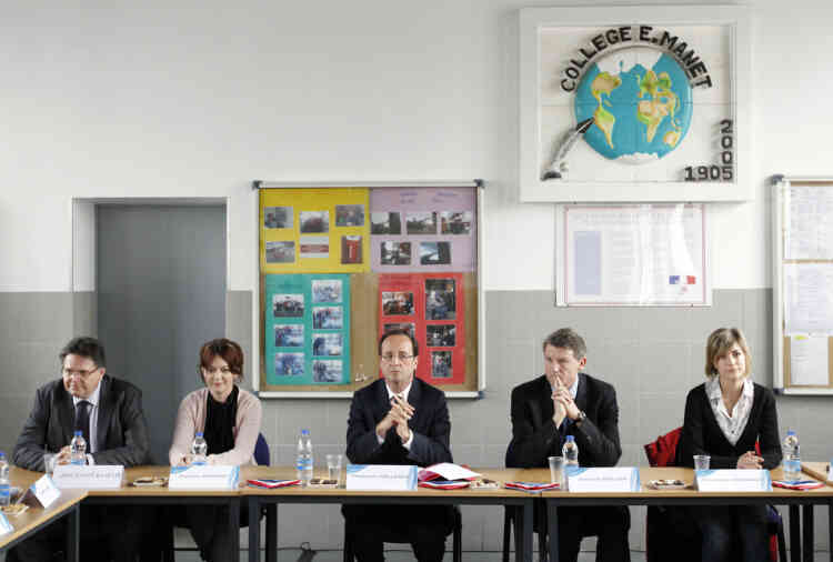 France's Socialist Party (PS) candidate for the 2012 French presidential election Francois Hollande (C) next to (L) European socialist MP and his Education campaign advisor Vincent Peillon (2nd R), listen to teachers and students families, during a visit at the Edouard Manet college, in Villeneuve-la-Garenne, a Paris suburb, on March 6, 2012.       AFP PHOTO POOL / PATRICK KOVARIK