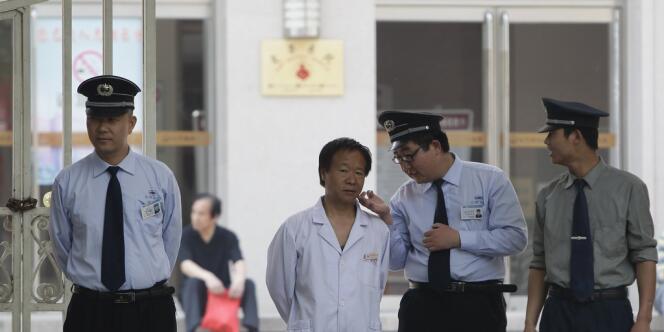 Un membre de l'hôpital de Chaoyang, où est soigné Chen Guangcheng, et des agents de sécurité, le 8 mai.