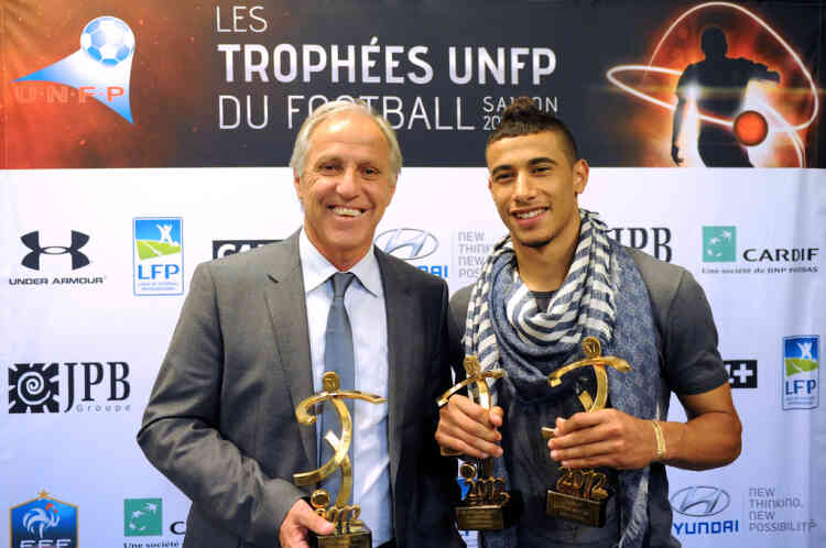 Montpellier's forward Younes Belhanda (R) and Montpellier's head coach Rene Girard (L) pose after receiving respectively the best hope L1 player trophy and the best L1 coach trophy during the TV show "Canal Football Club" on May 14, 2012 in Paris, as part of the 20th edition of the UNFP (French National Professional Football players Union) trophy ceremony. AFP PHOTO / FRANCK FIFE
