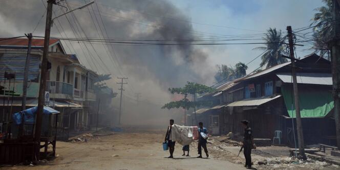 Un militaire surveille des résidents de Sittwe évacuant quelques-uns de leurs biens, le 12 juin 2012.
